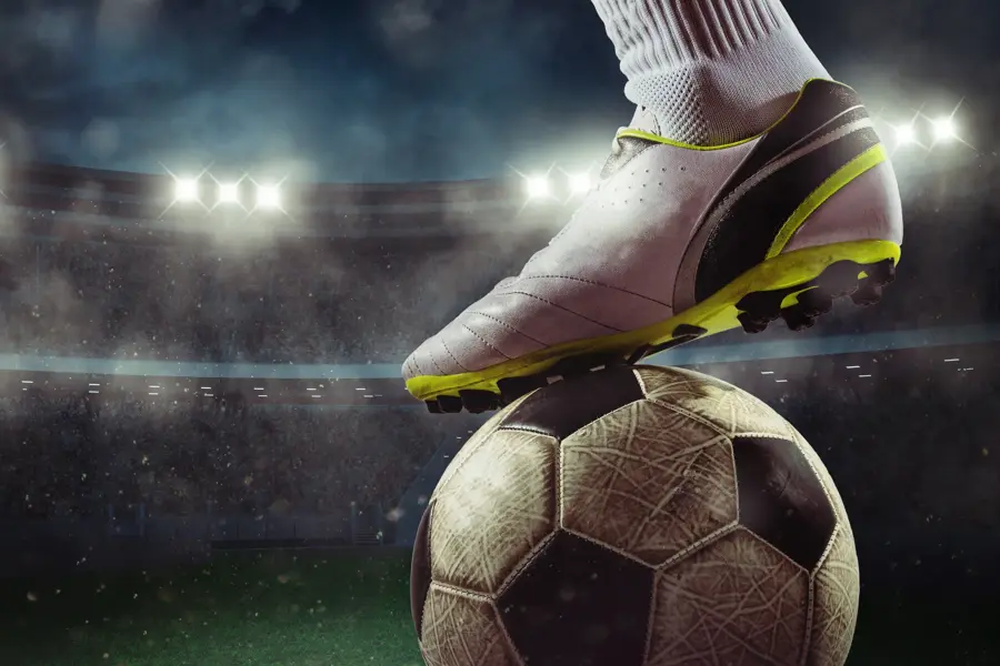 Football scene at night match with player ready to shoot the ball