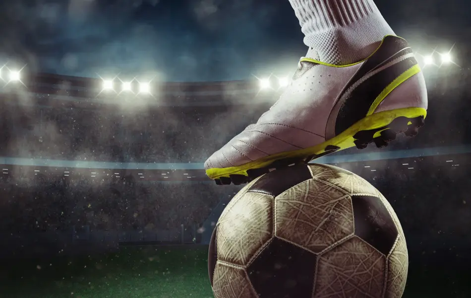 Football scene at night match with player ready to shoot the ball