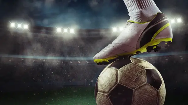 Football scene at night match with player ready to shoot the ball