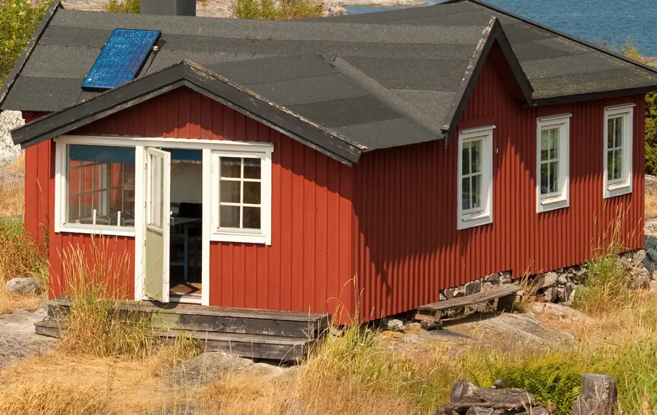 Rød hytte ved kysten, havet, svaberg, sommer.
