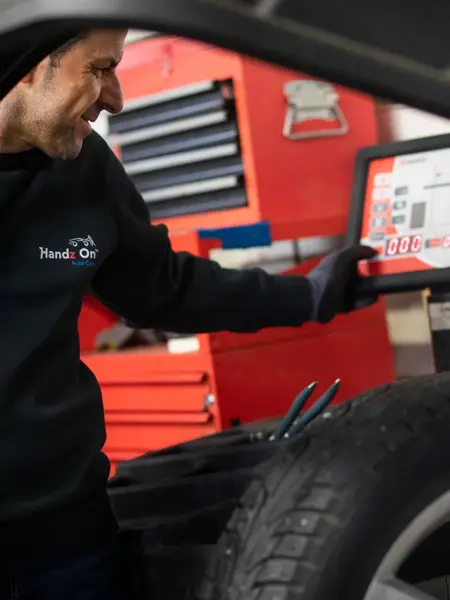 Mann sjekker lufttrykk i dekk