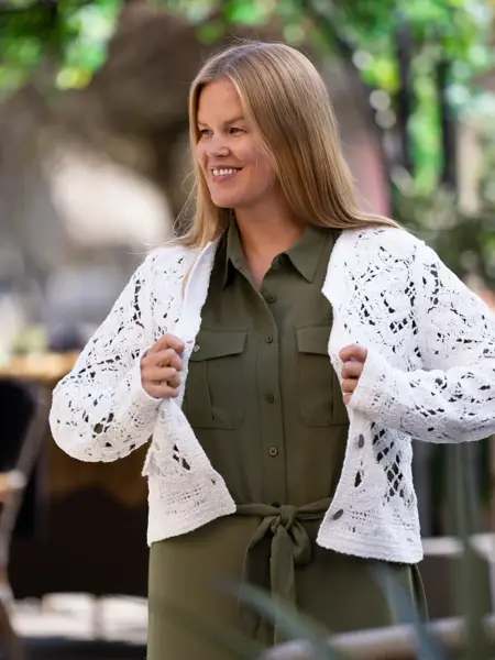 Dame med militærgrønn skjortekjole og hvit cardigan