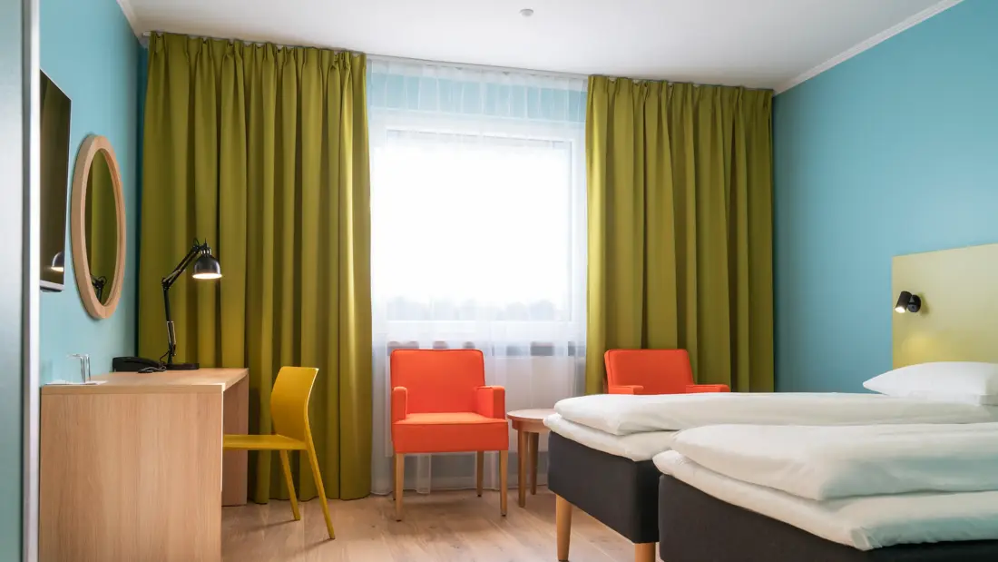 Seng, skrivebord og stoler med bord i twin rom på Thon Hotel Gardermoen