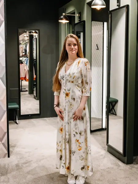 dame i kjole står foran prøverom