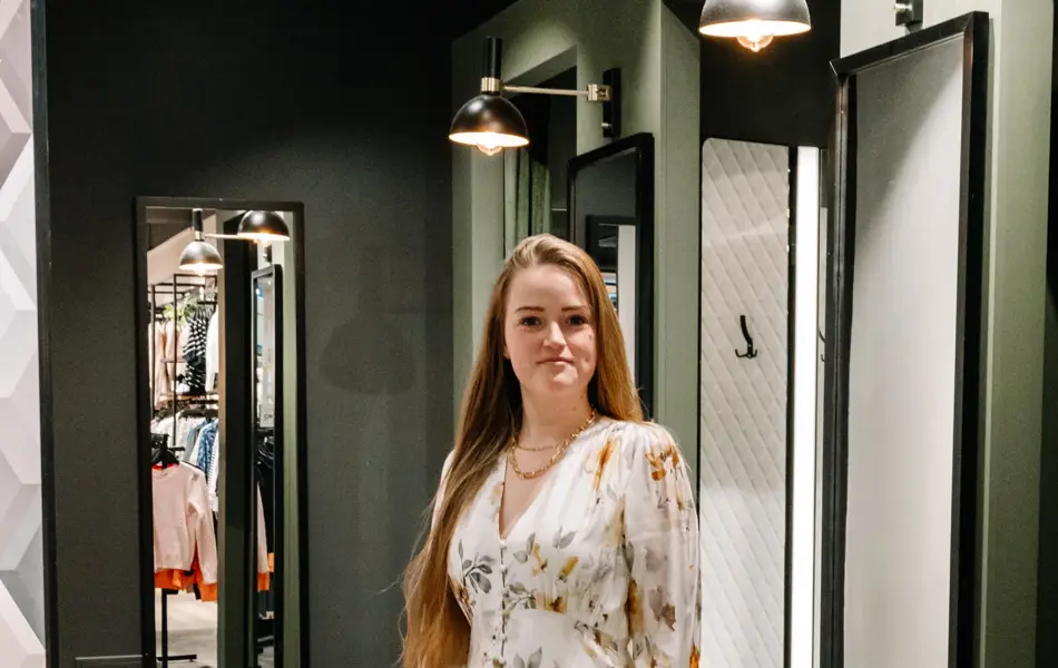 dame i kjole står foran prøverom