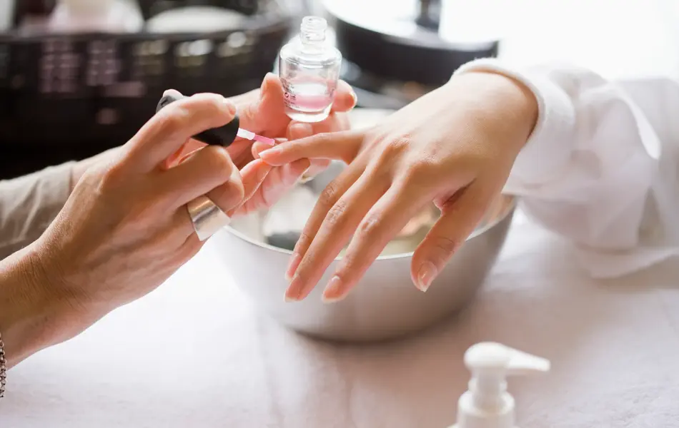 dame som får manikyr av neglespesialist