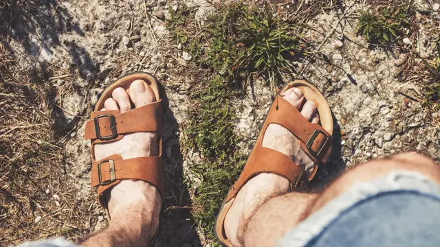 Nærbilde av manns føtter i brune skinnsandaler med dobbel reim. Illustrasjonsbilde til artikkel om vårmote for sko.