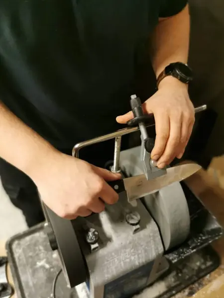 Mann som sliper en kniv