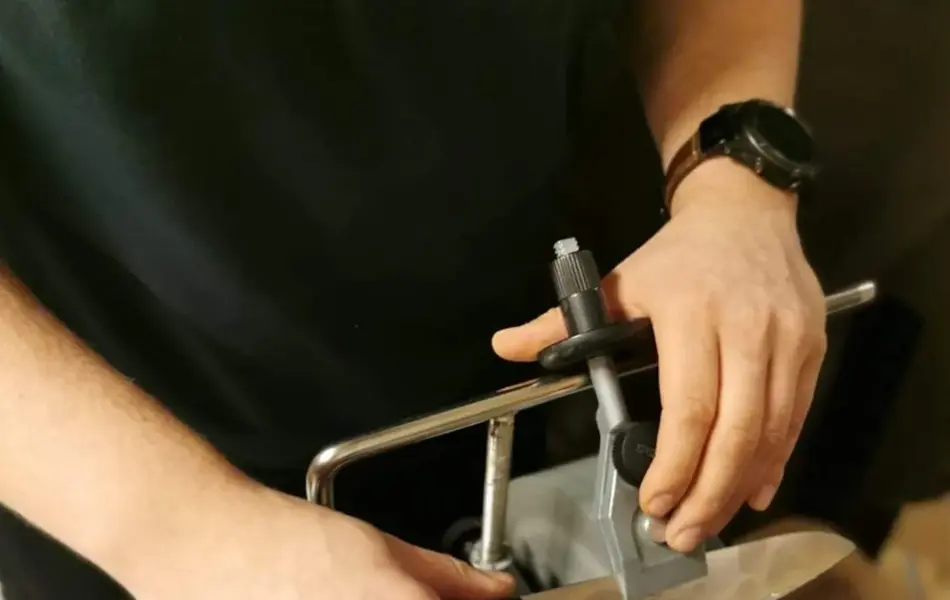 Mann som sliper en kniv