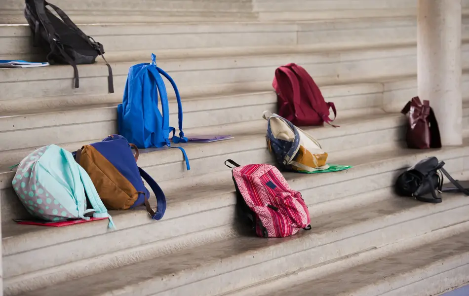 Flere skolesekker som står på en trubune