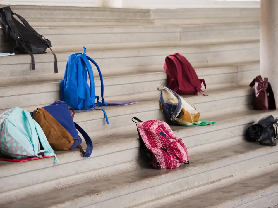 Flere skolesekker som står på en trubune