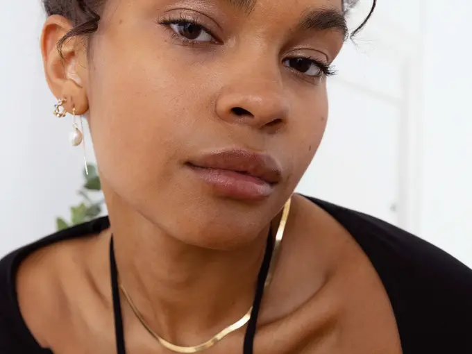 modell med øredobber og gullkjede