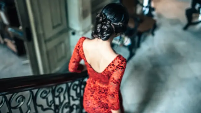 beautiful young cuban woman in red dress going down stairs in old house