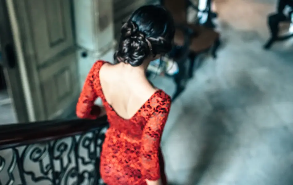 beautiful young cuban woman in red dress going down stairs in old house