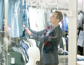 person ser på klær i herrebutikk