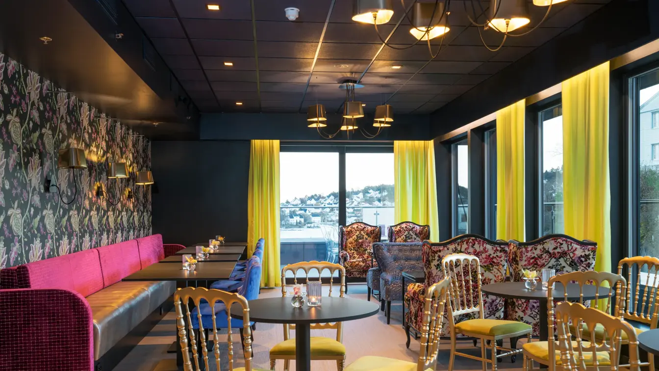 Lounge med behagelige sitteplasser og fargerik tapet på Thon Hotel Arendal i Arendal sentrum