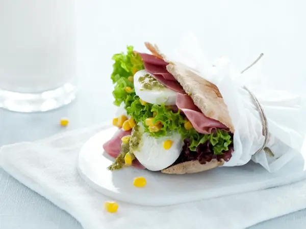 Et pitabrød fylt med mozzarella og skinke i en matpakkepapir