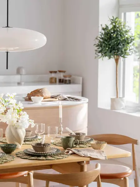 Kjøkkenbord tildekket med servise og blomster i vaser