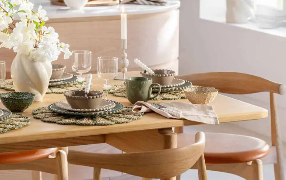 Kjøkkenbord tildekket med servise og blomster i vaser