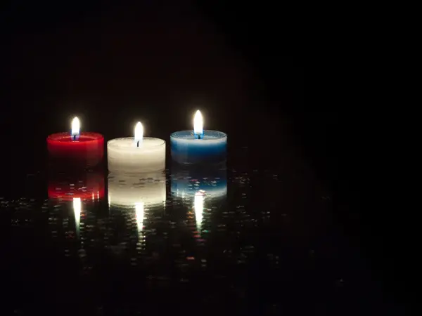 Nærbilde av telys i rødt, hvitt og blått på svart bakgrunn. Foto til artikkel om 17. mai-dekorasjoner.