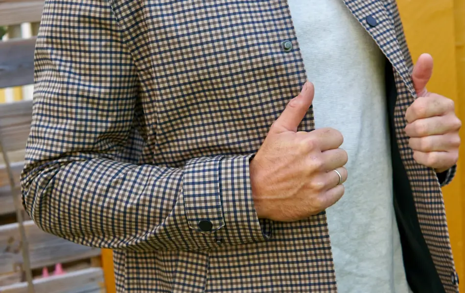 Mann med som holder en rutete jakke åpen