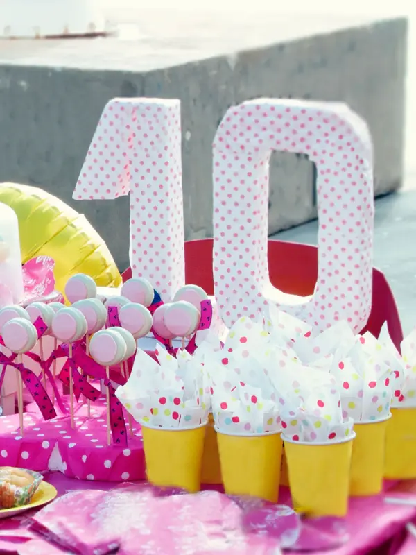 Bord pyntet til bursdag med stor ti-tall og rosa pynt og mat