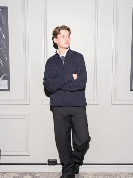 Gutt som står lent mot en vegg