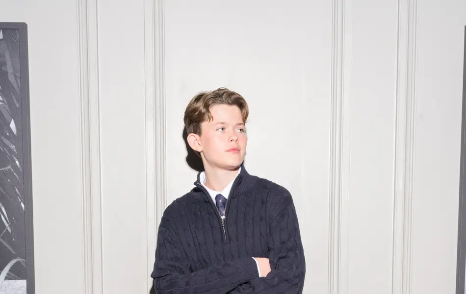 Gutt som står lent mot en vegg