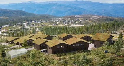 Oversiktsbilde over hytteområdet i Turufjell, med hytter i forgrunn og horisont med fjell