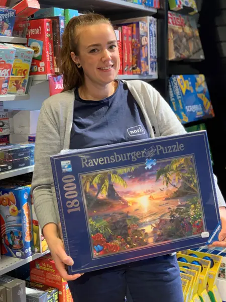 ansatt hos norli viser frem puslespill