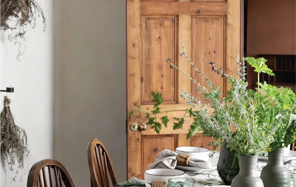 Spisebord dekket med servise og grønne planter i vaser