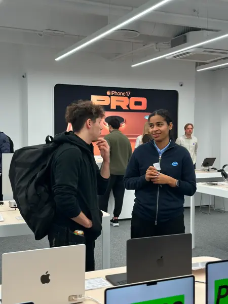 bilde fra butikken eplehuset hvor man ser en ansatt og en kunde og en del mac-produkter på et bord