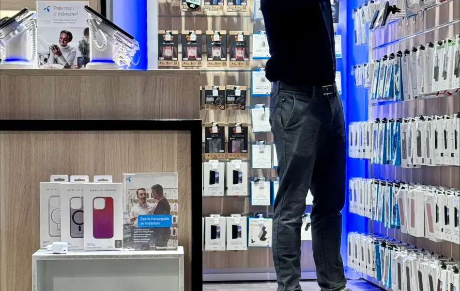 Mann fra Telenorbutikken som rydder i hyller
