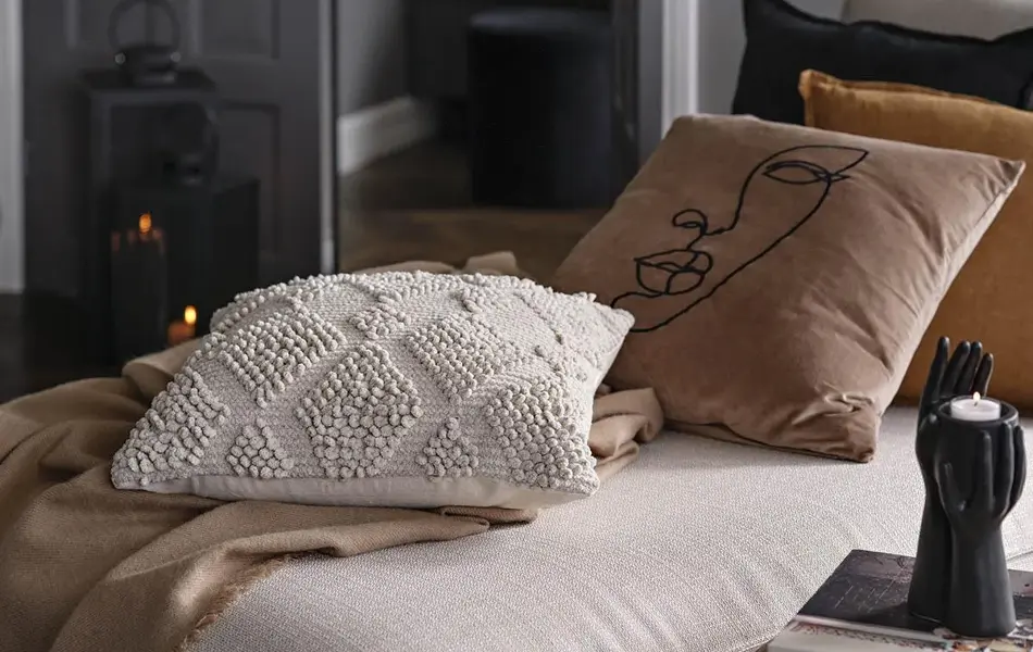 Beige sofa med puter i bruntoner