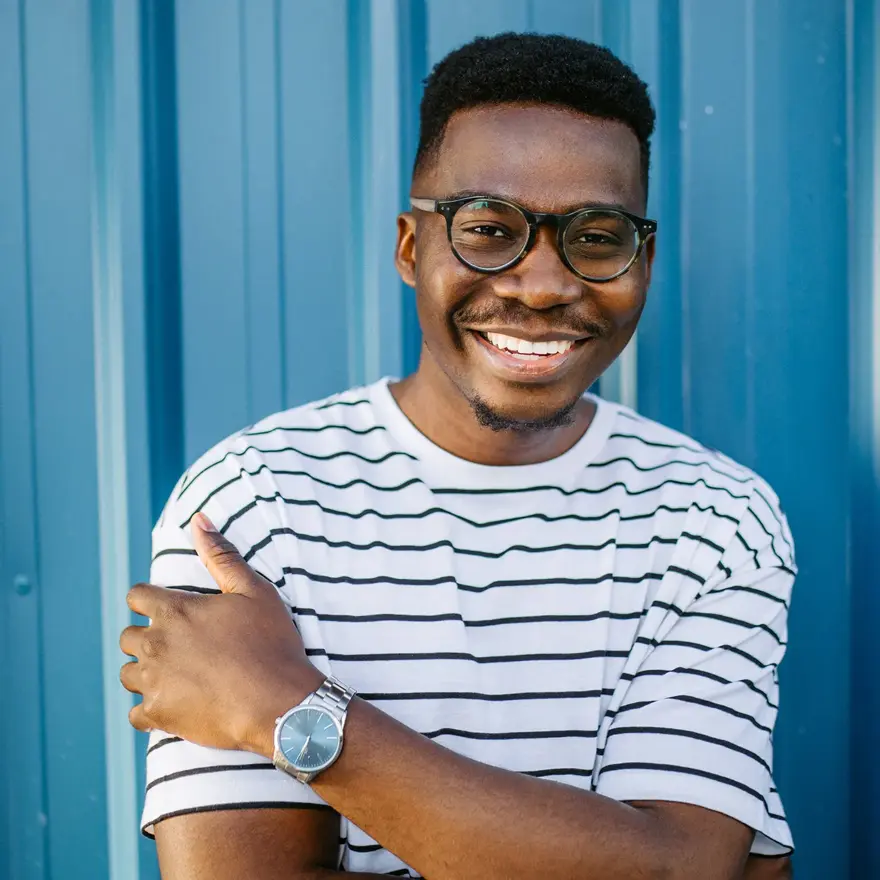 Mann med stripete t-skjorte og briller poserer foran blå vegg 