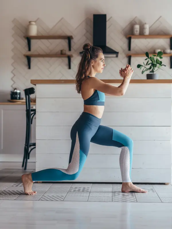 Fit woman exercising at home doing lunges exercise
