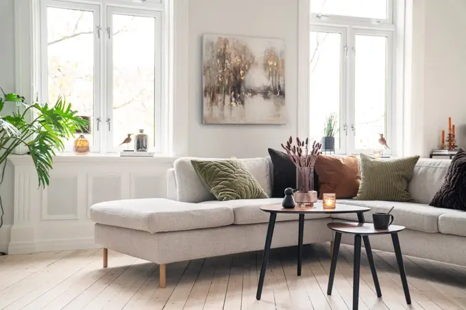Beige sofa med puter i jordtoner