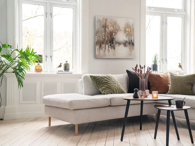 Beige sofa med puter i jordtoner