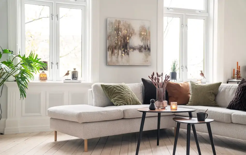 Beige sofa med puter i jordtoner