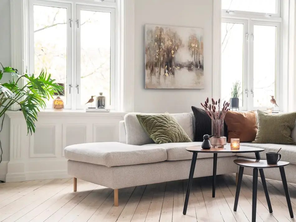 Beige sofa med puter i jordtoner
