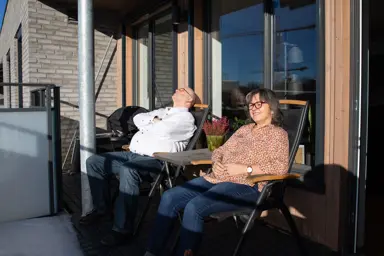 Bilde av Henning Granum og Torill Fjæran-Granum som sitter i hver sin stol på verandaen deres på Skårerløkka