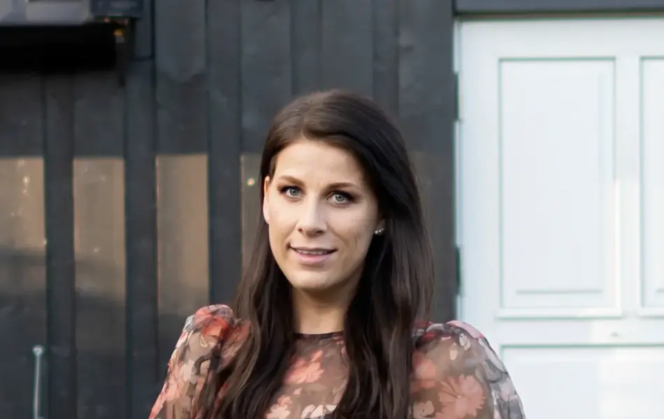 Dame med blomsterbluse og hvit bukse