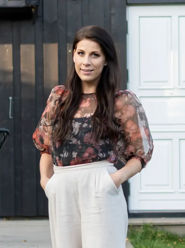 Dame med blomsterbluse og hvit bukse