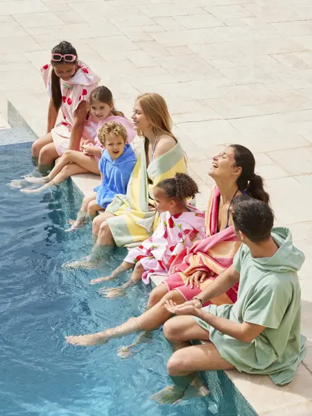 Familie som sitter ved bassengkanten