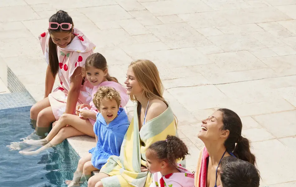 Familie som sitter ved bassengkanten