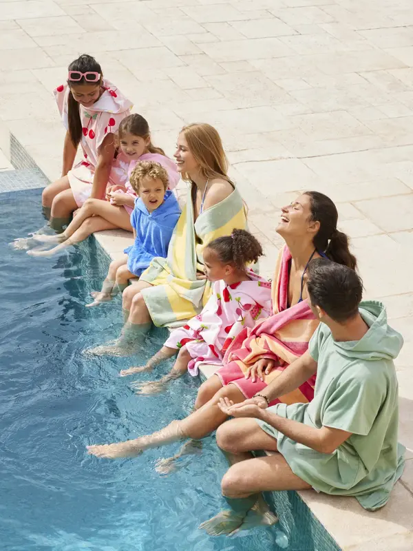 Familie som sitter ved bassengkanten