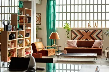 En fargerik stue med sofa og stuebord med to lenestoler og hyller