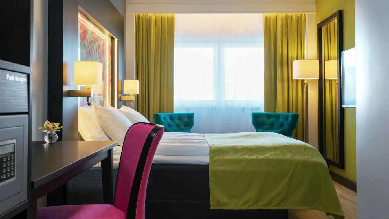 Dobbeltseng på double room med rosetapet ,skrivepult og safe på Thon Hotel Arendal i Arendal sentrum