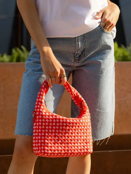 Dame som holder en rød veske