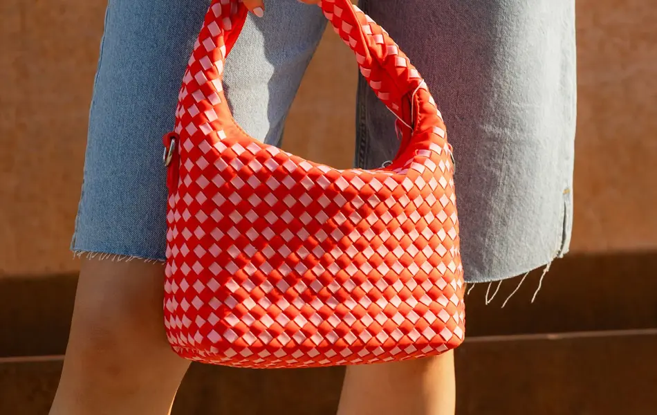 Dame som holder en rød veske